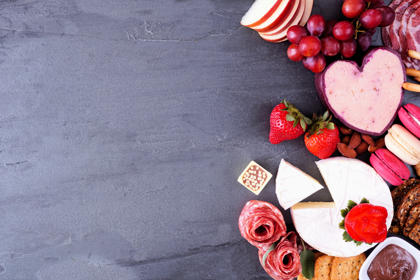 Valentines Day charcuterie side border on a slate background